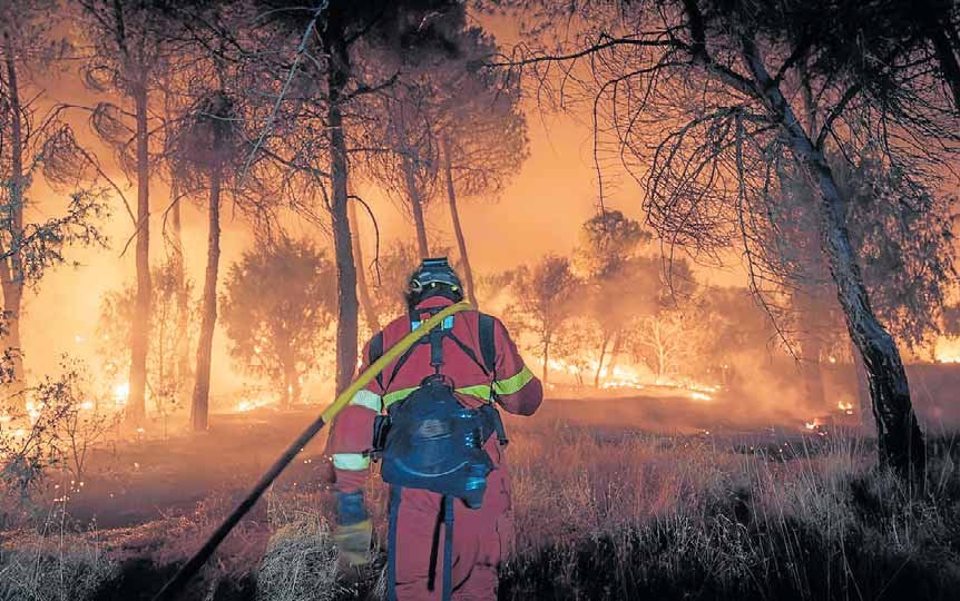 Un bombero lucha contra el incendio de Madrid y Ávila
